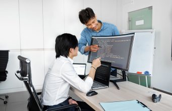 Checks Product Teams Need to Run Before Wiring Up a Public-Record API Engineers reviewing code on a monitor: Checks Product Teams Need to Run Before Wiring Up a Public-Record API