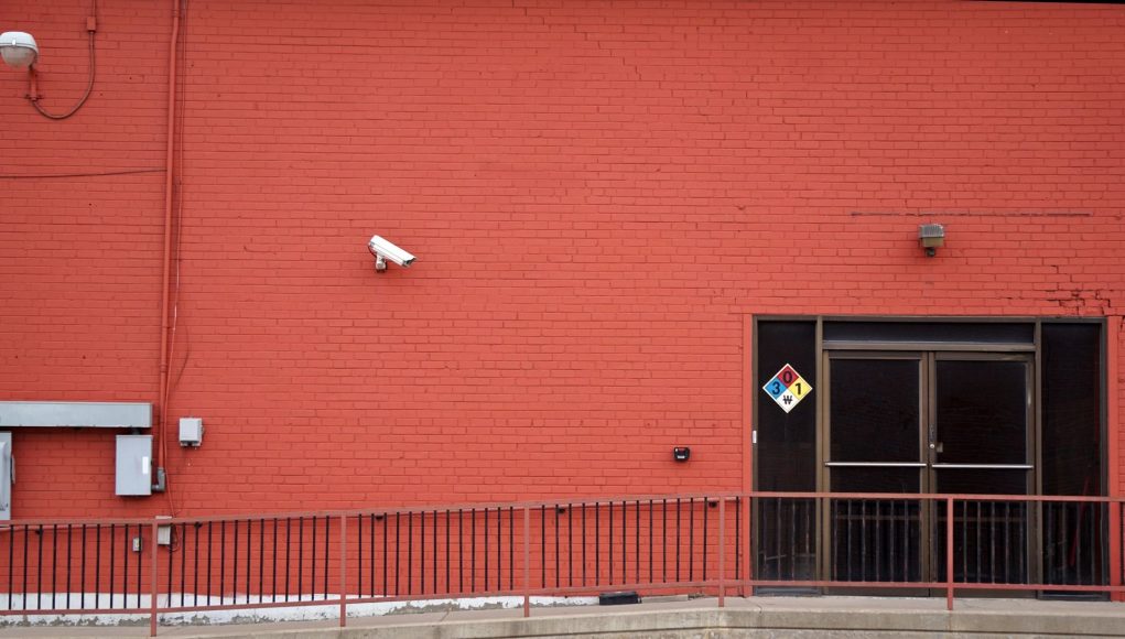 Security camera and rear entrance on a commercial building: Crime Forecast to Hit Nearly One UK Business in Three This Year