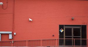 Security camera and rear entrance on a commercial building: Crime Forecast to Hit Nearly One UK Business in Three This Year