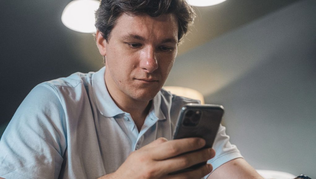 A young man reading the news on his smartphone