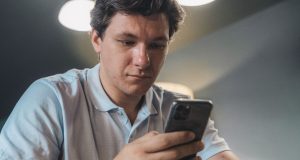 A young man reading the news on his smartphone