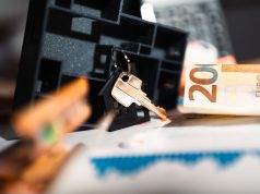 Keys with a house model, Euro bills, and charts suggesting real estate and financial themes.