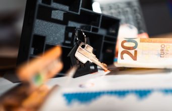 Why the American Federal Funds Rate Matters for Mortgage Borrowing in Britain Keys with a house model, Euro bills, and charts suggesting real estate and financial themes.