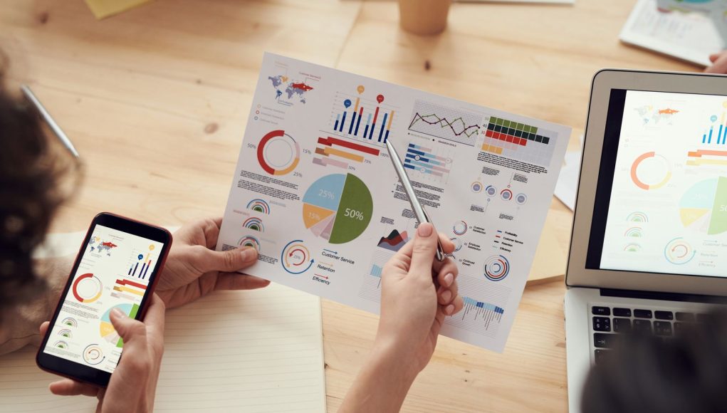 Great PPC and SEO Partners Are Built on Industry-Specific Experience: marketing specialists reviewing SEO and campaign analytics charts at a desk