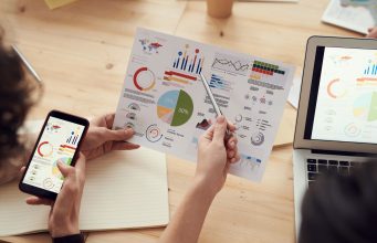 Great PPC and SEO Partners Are Built on Industry-Specific Experience: marketing specialists reviewing SEO and campaign analytics charts at a desk
